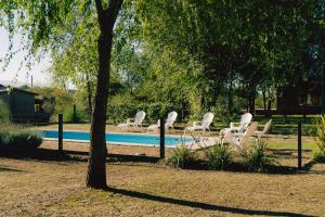 a group of white lounge chairs next to a pool at Entre Campos in Los Reartes
