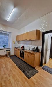 an empty kitchen with wooden cabinets and a large window at Ferienwohnung Kinheim an der Mosel in Kinheim
