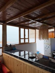 a kitchen with a counter top in a room with windows at Mira Guest House in Taghazout +41 photos