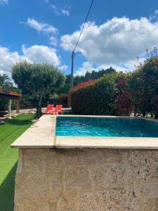 a swimming pool with two chairs in a yard at Refúgio da Cancela - Arouca Stay in Arouca