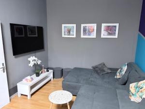 a living room with a couch and a flat screen tv at Ferienwohnung Kinheim an der Mosel in Kinheim