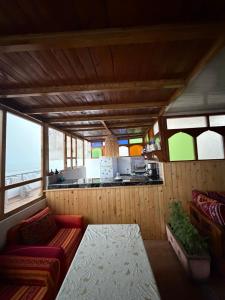 a living room with a couch and a kitchen at Mira Guest House in Taghazout
