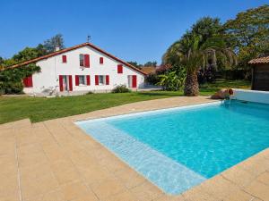 a large swimming pool in front of a house at Le Chalet des Pins - La Forge De Clermont in Clermont