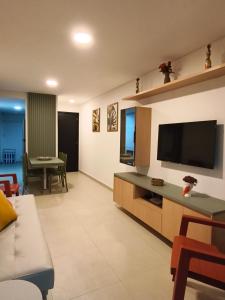 a living room with a couch and a flat screen tv at PARK DEL PRADO - Conforto pertinho do mar in Cabedelo