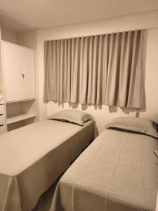 two beds sitting next to each other in a bedroom at PARK DEL PRADO - Conforto pertinho do mar in Cabedelo +23 photos