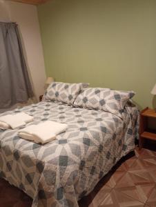 a bedroom with a bed with two towels on it at Corazón Contento in Villa Pehuenia
