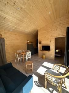 a living room with a couch and a table at Le chalet des Marais in Saint-Molf
