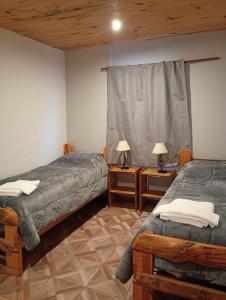 a bedroom with two beds and two lamps on tables at Corazón Contento in Villa Pehuenia