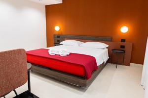 a bedroom with a large bed with a red blanket at Villa delle Rose Pompei Rooms and Suite in Pompei