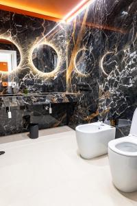 a bathroom with a toilet and a black marble wall at Villa delle Rose Pompei Rooms and Suite in Pompei