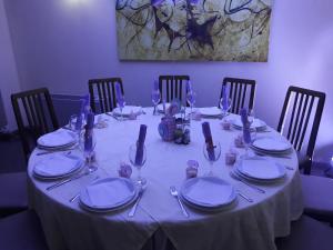 ein Tisch mit einer weißen Tischdecke und Tellern und Besteck in der Unterkunft Hotel Bella Donna in Kumanovo