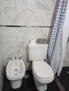 a bathroom with a white toilet and a sink at Corazón Contento in Villa Pehuenia