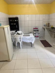 a kitchen with a table and a refrigerator at Casa Fronteira in Oiapoque +3 photos