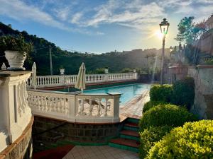 a swimming pool with a white fence and a light pole at Villa Azzurra in Massa Lubrense
