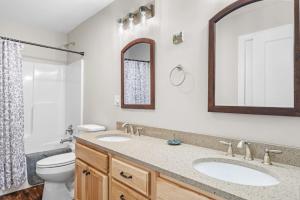 a bathroom with two sinks and a toilet and a mirror at All Decked Up - wifi, view, river access, fire pit, 3 bedrooms, games, family friendly in Great Cacapon +98 photos