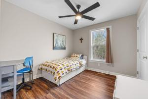 a bedroom with a bed and a desk and a window at All Decked Up - wifi, view, river access, fire pit, 3 bedrooms, games, family friendly in Great Cacapon