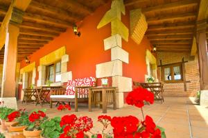 a patio with red flowers and a building at Posada La Fabula in Santillana del Mar