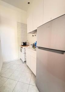 a kitchen with white cabinets and a refrigerator at L'Oasi nel Centro in Ariano Irpino +15 photos