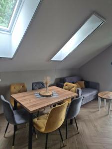 a dining room with a wooden table and chairs at Dom za wydmą in Nielbark