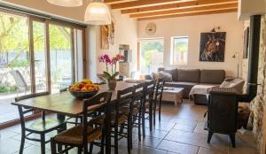 a kitchen and living room with a table and chairs at Gîte Le Verger in Traize