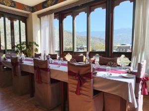 a dining room with tables with chairs and windows at Dream Janka Boutique in Paro