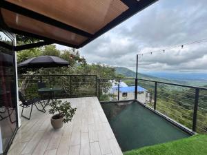 a balcony with a pool and a table and an umbrella at Ecoesferas Glamping in La Ese