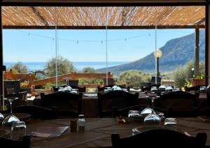 a restaurant with tables and chairs and a large window at Agriturismo Paulesa in Dorgali