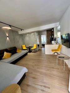 a living room with a couch and yellow chairs at SMART COASTAL RETREAT Apartment in Alexandroupoli