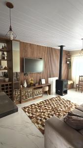 a living room with a flat screen tv and a couch at Casa- Encanto da Praça in Urupema +20 photos