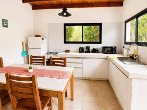 a kitchen with white cabinets and a table and chairs at Mirando al Mar I in Mar Azul