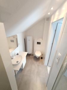 a white bathroom with a toilet and a sink at VILLA KINGA ROWy in Rowy +79 photos