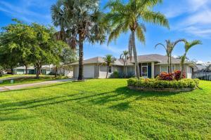 a house with palm trees in a yard at Paradise Vacay in Sebastian