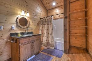 a bathroom with a sink and a shower in a cabin at Squirrels Hideaway Fire Pit MTN Views in Copperhill +23 photos