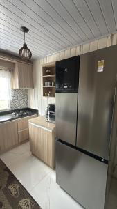 a kitchen with a stainless steel refrigerator in it at Casa- Encanto da Praça in Urupema