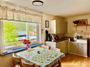 a kitchen with a table and a kitchen with a window at Fjord Haven in Gryllefjord