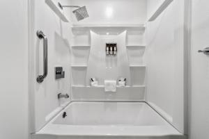 a white bathroom with a shower and a sink at The Snoozzz Inn in Eureka +30 photos
