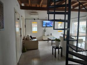 a living room with a spiral staircase in a living room at PARQUE LELOIR, ITUZAINGO in Villa Leloir