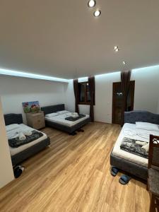 two beds in a room with wooden floors at Guesthouse Dritan Selimaj in Valbonë +10 photos