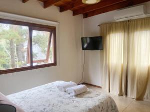 a bedroom with a bed and a window and a television at Mirando al Mar I in Mar Azul