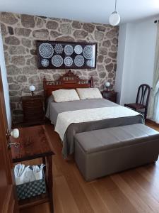 a bedroom with a bed and a stone wall at Casa Pires Mateus in Monsanto