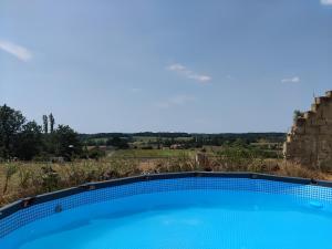 a blue swimming pool with a view of a field at Pavilion de LaFue in Lavergne