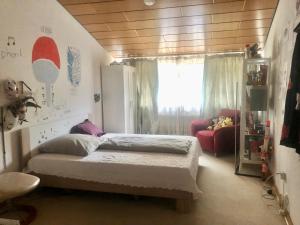 a bedroom with a bed and a chair and a window at Only Lady Kaarst in Kaarst