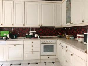 a kitchen with white cabinets and a stove top oven at Only Lady Kaarst in Kaarst