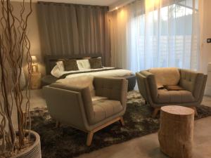 - un salon avec deux chaises et un lit dans l'établissement LOFT SPA - Côté château., à Carcassonne