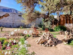 a garden with a pile of logs and flowers at Guasamayo in Tilcara
