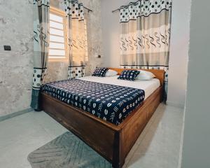 a bedroom with a bed in a room with curtains at Hôtel Merveille Lomé in Lomé