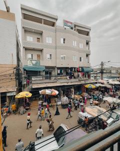 a group of people walking around a market in front of a building at Hôtel Merveille Lomé in Lomé