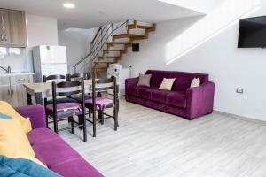a living room with a purple couch and a table at Bebi Hotel And Apartments in Sarandë