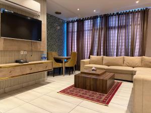 a living room with a couch and a flat screen tv at The Horizon Hotel Islamabad in Islamabad