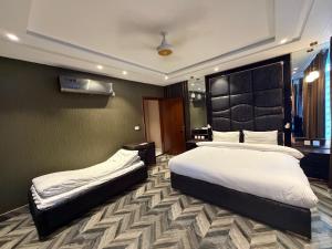 a hotel room with two beds in a bedroom at The Horizon Hotel Islamabad in Islamabad
